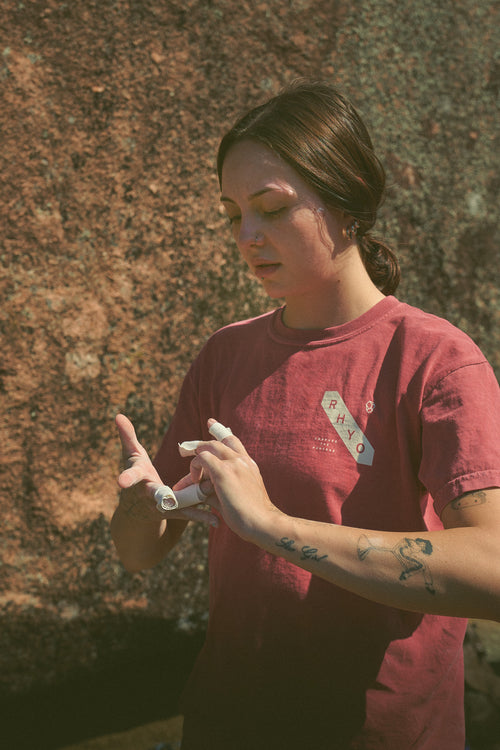Person in a Rhyo / 02: Process t-shirt wrapping their fingers in tape before rock climbing.